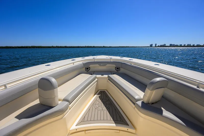 Slide: The Image of 2023 Scout 355 LXF boat, spacious seating, open water view, clear blue sky. - 15