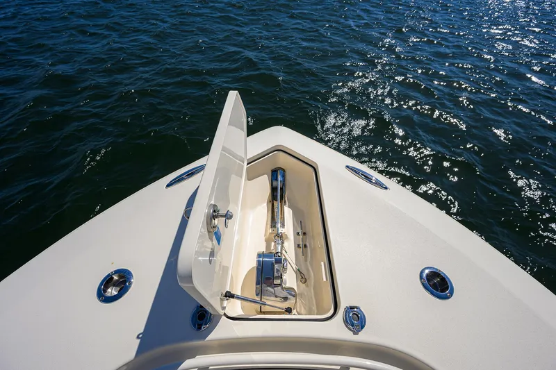 Slide: The Image of 2023 Scout 355 LXF boat anchor compartment open on calm water. - 17