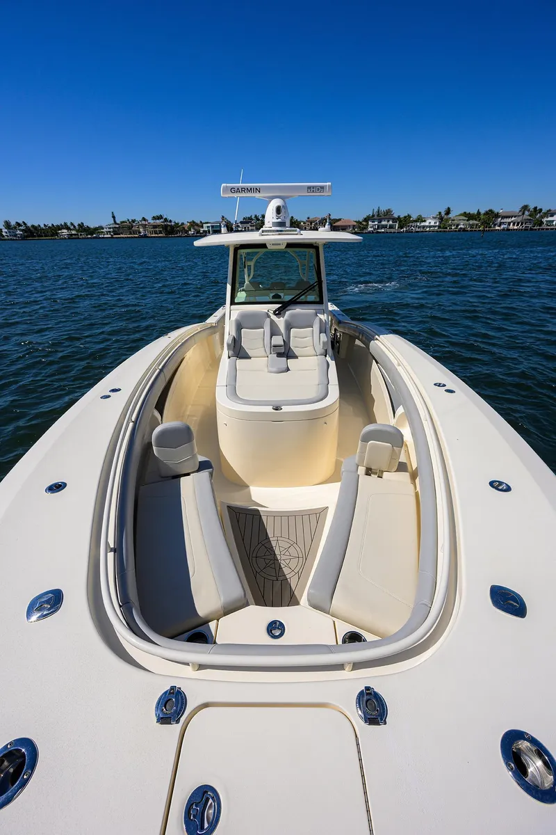Slide: The Image of 2023 Scout 355 LXF boat on water, showcasing sleek design and spacious seating. - 18