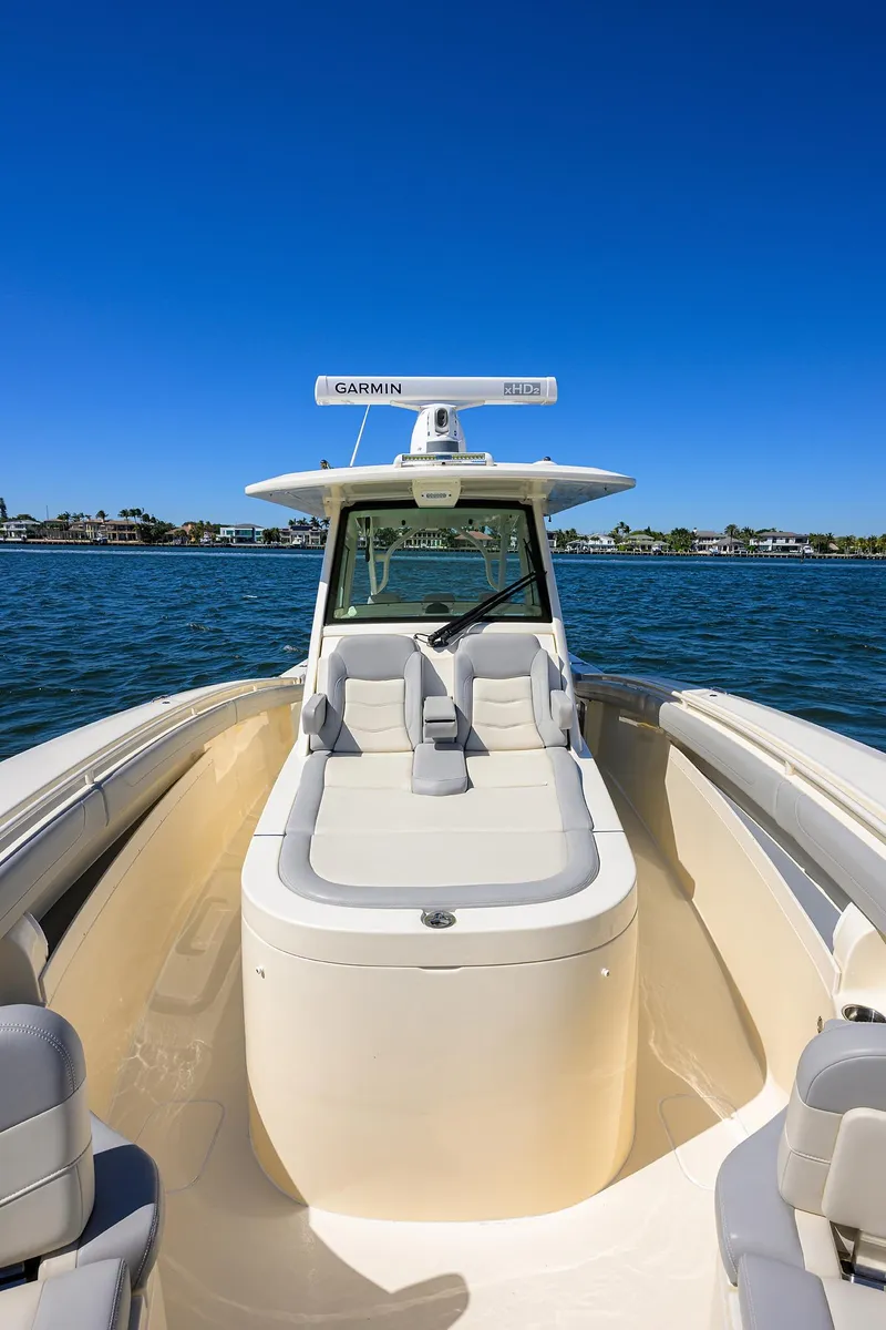 Slide: The Image of 2023 Scout 355 LXF boat on water, clear sky, luxurious seating. - 20