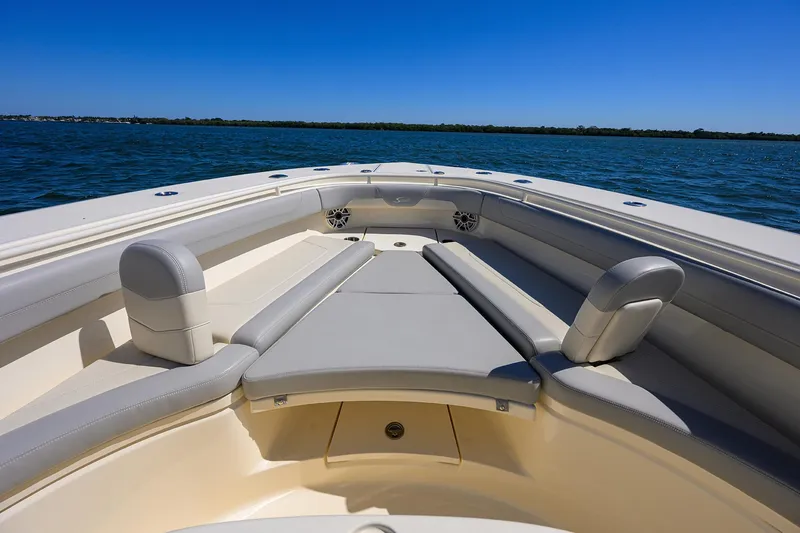 Slide: The Image of 2023 Scout 355 LXF boat interior with cushioned seating on open water. - 23
