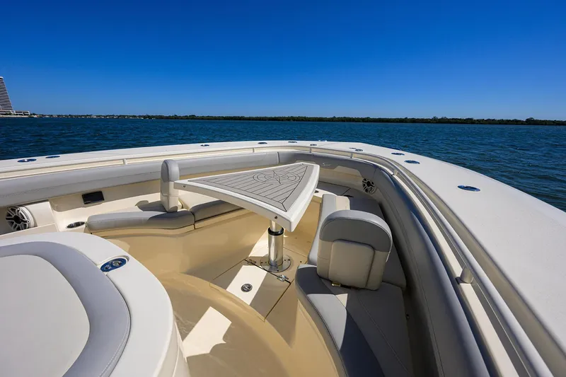 Slide: The Image of 2023 Scout 355 LXF boat interior with seating, on a sunny day at sea. - 26