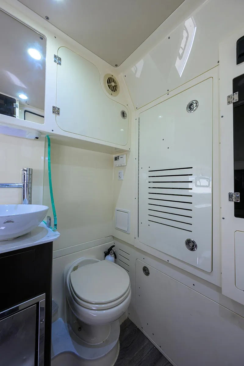 Slide: The Image of 2023 Scout 355 LXF boat bathroom interior with modern fixtures and storage cabinets. - 34