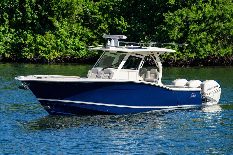 Slide: The Image of 2023 Scout 355 LXF boat on water, surrounded by lush greenery. - 4
