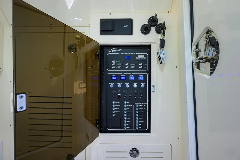 Slide: The Image of 2023 Scout 355 LXF electrical panel with open cover, showcasing controls and switches. - 43