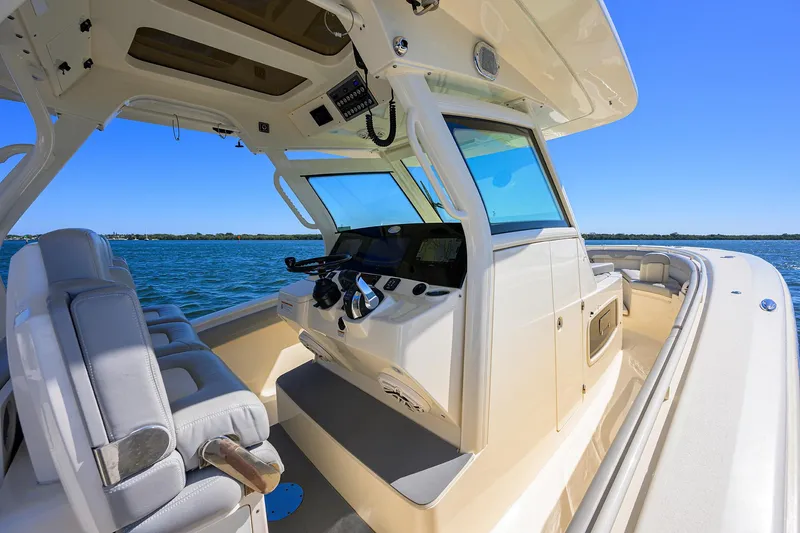 Slide: The Image of 2023 Scout 355 LXF boat interior with helm, seats, and ocean view. - 45