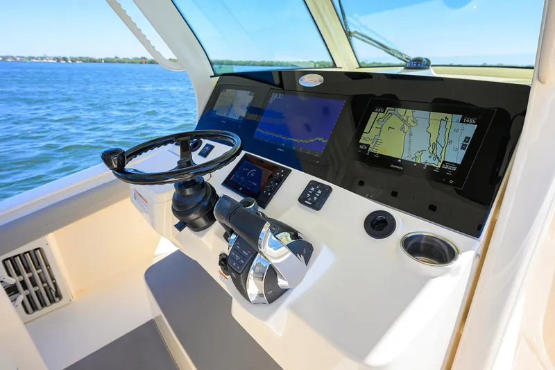 Slide: The Image of 2023 Scout 355 LXF helm with advanced navigation displays on open water. - 46