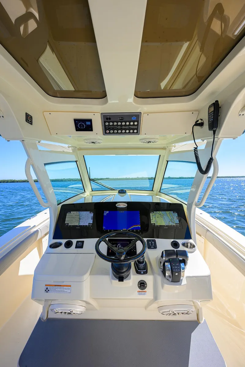 Slide: The Image of 2023 Scout 355 LXF boat cockpit with advanced navigation system and ocean view. - 48