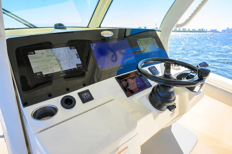 Slide: The Image of 2023 Scout 355 LXF boat helm with advanced navigation displays and steering wheel. - 49