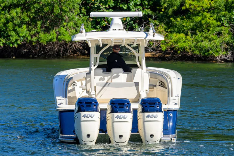 Slide: The Image of 2023 Scout 355 LXF boat with triple 400 horsepower engines on water. - 9