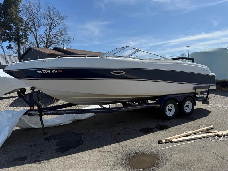 Slide: The Image of 1998 Four Winns 240 Horizon boat on trailer, parked outdoors under clear sky. - 3