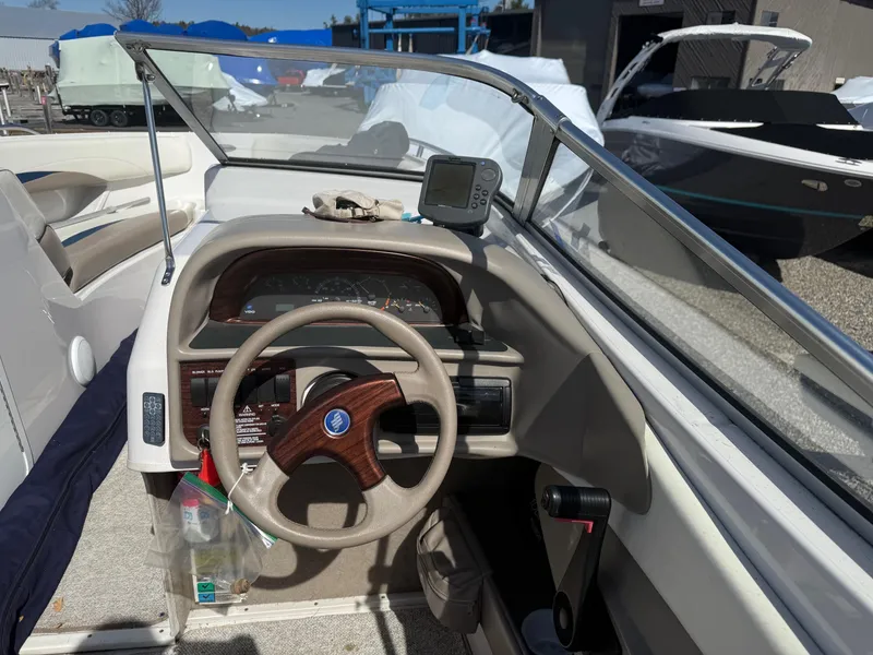 Slide: The Image of 1998 Four Winns 240 Horizon boat dashboard with steering wheel and navigation equipment. - 7