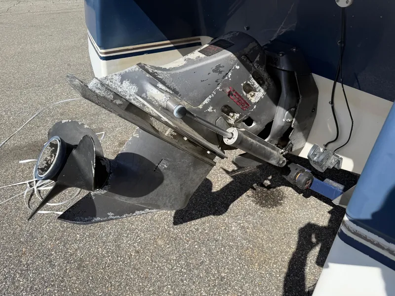 Slide: The Image of 1998 Four Winns 240 Horizon boat outdrive on pavement, showing wear and corrosion. - 9