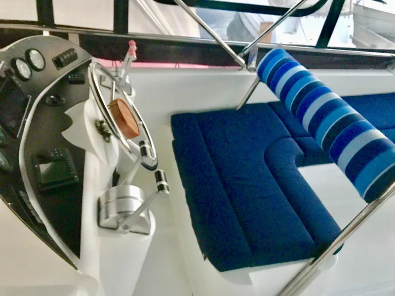 Slide: The Image of Deck view of Prima 5230 boat, 1999 model, with striped seating, overlooking a serene lake. - 3