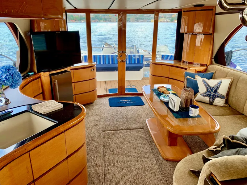 Slide: The Image of Luxurious Prima 5230 yacht interior with plush seating and elegant wooden accents, dockside view. - 9