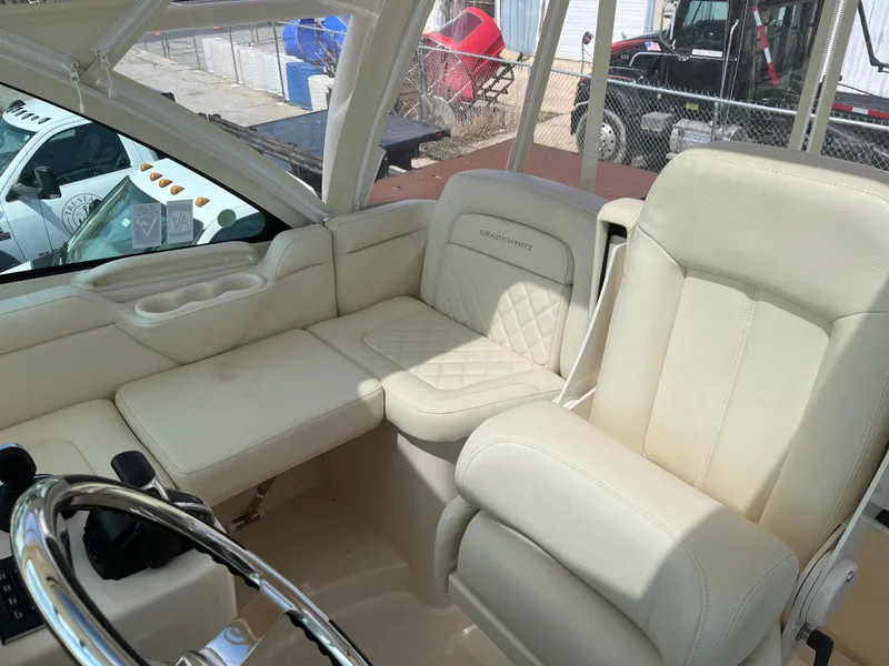 Slide: The Image of 2023 Grady-White Express 330 boat interior with luxurious cream seating and steering wheel. - 11