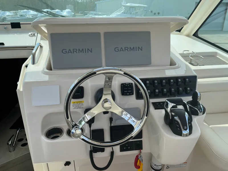 Slide: The Image of 2023 Grady-White Express 330 helm with dual Garmin displays and steering wheel. - 12