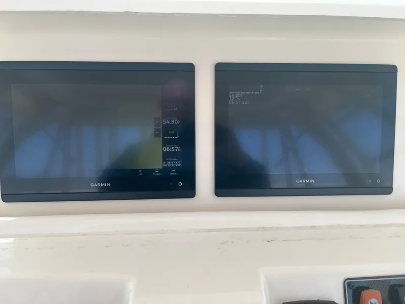 Slide: The Image of Dual Garmin displays on 2023 Grady-White Express 330 boat dashboard. - 13