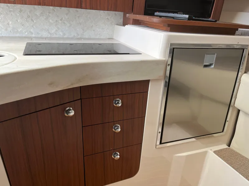 Slide: The Image of 2023 Grady-White Express 330 boat interior with modern kitchen cabinetry and stainless steel appliances. - 20