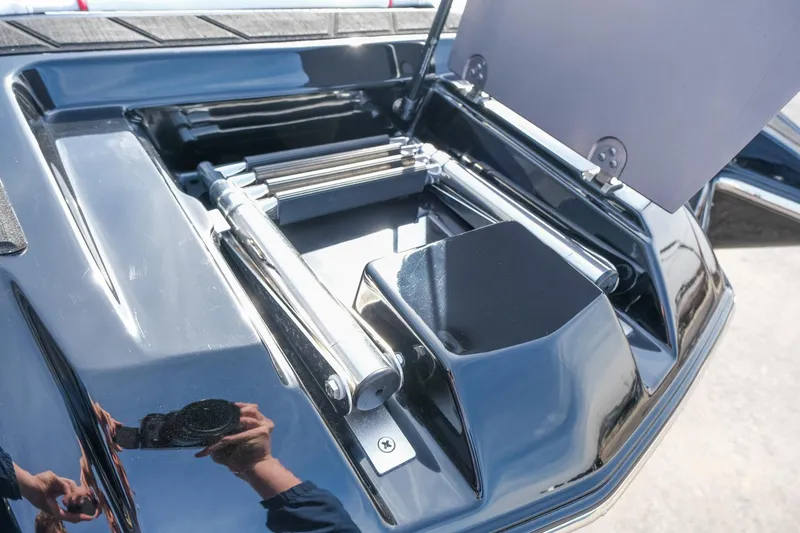 Slide: The Image of 2017 Malibu Wakesetter 22 MXZ boat storage compartment with open lid and metal components. - 10