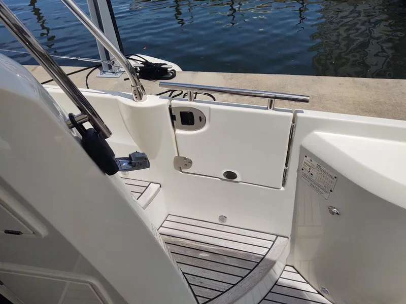 Slide: The Image of 2020 Prestige 520S yacht deck with white railing and wooden flooring by the water. - 10