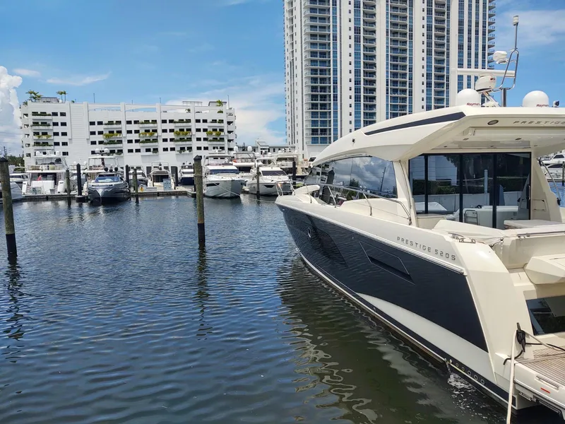 Slide: The Image of Luxury 2020 Prestige 520S yacht docked in marina, with cityscape backdrop. - 3