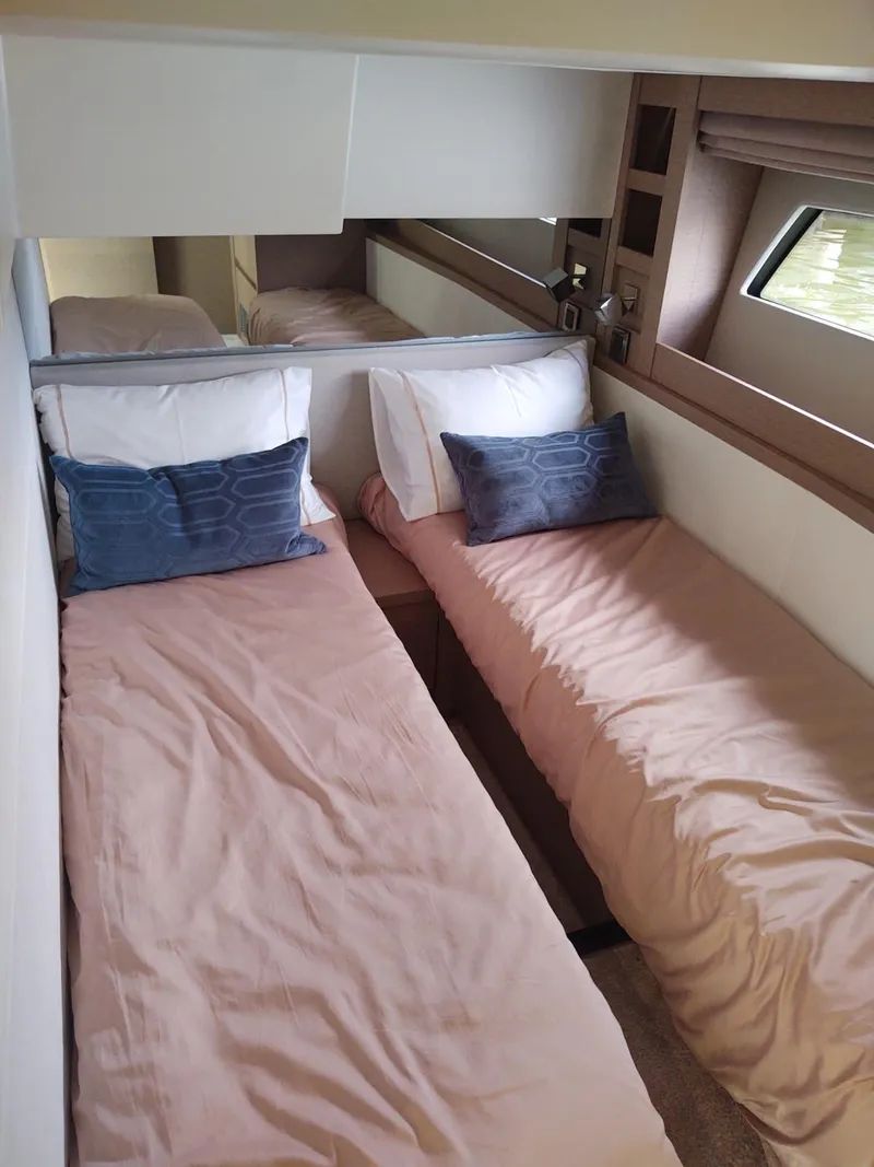 Slide: The Image of Twin beds in a 2020 Prestige 520S yacht cabin with blue accent pillows. - 35