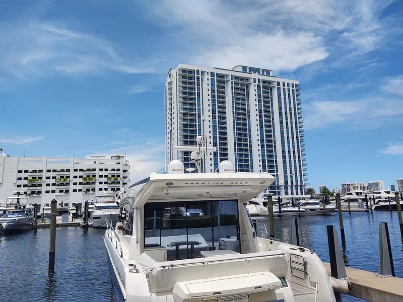 Slide: The Image of 2020 Prestige 520S yacht docked at marina with modern high-rise buildings in background. - 4