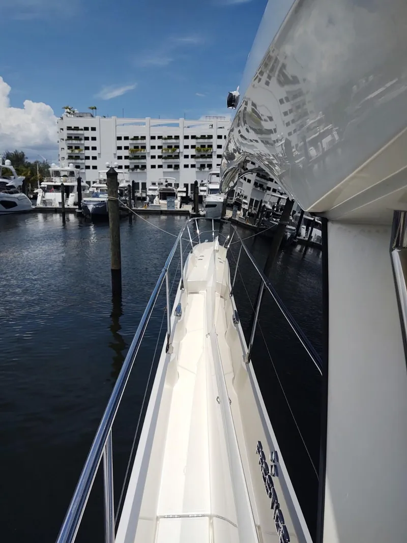 Slide: The Image of 2020 Prestige 520S yacht docked in marina, with modern buildings in the background. - 5