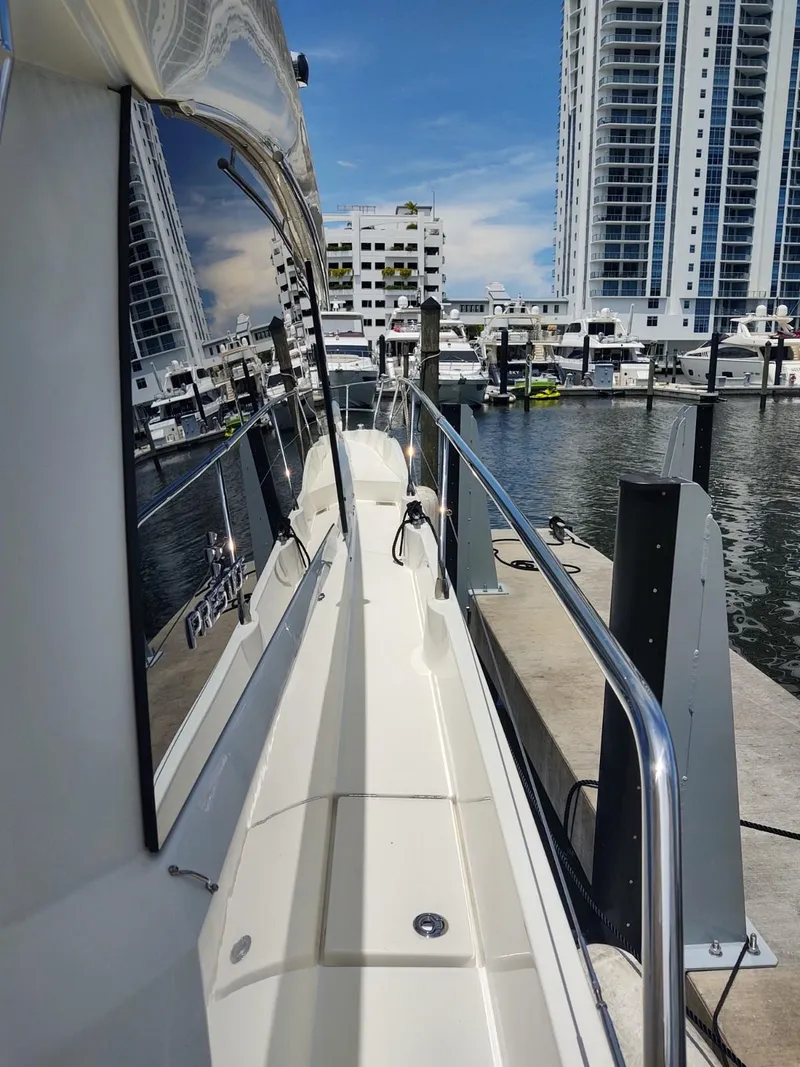 Slide: The Image of 2020 Prestige 520S yacht docked in a marina with cityscape background. - 6