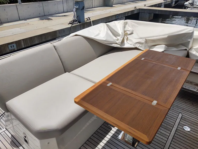Slide: The Image of 2020 Prestige 520S yacht with beige seating and wooden table at a marina. - 9