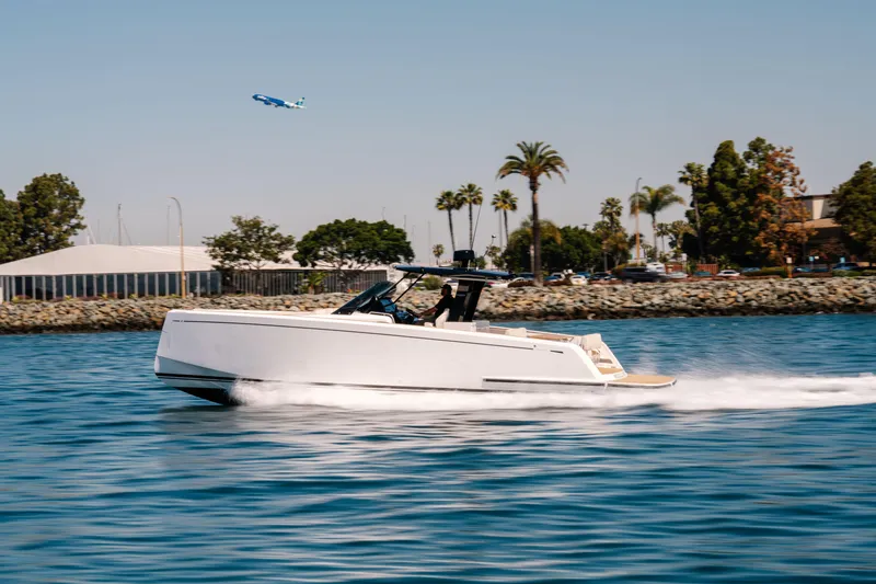 Slide: The Image of 2022 Pardo Yachts 38 cruising on water, palm trees and airplane in background. - 46