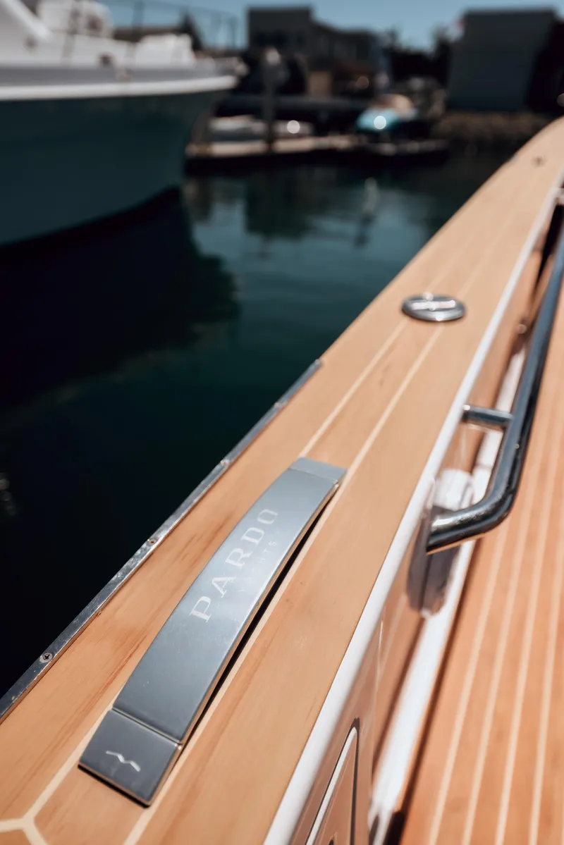 Slide: The Image of Pardo Yachts 38, 2022 model, sleek wooden deck detail by the water. - 28