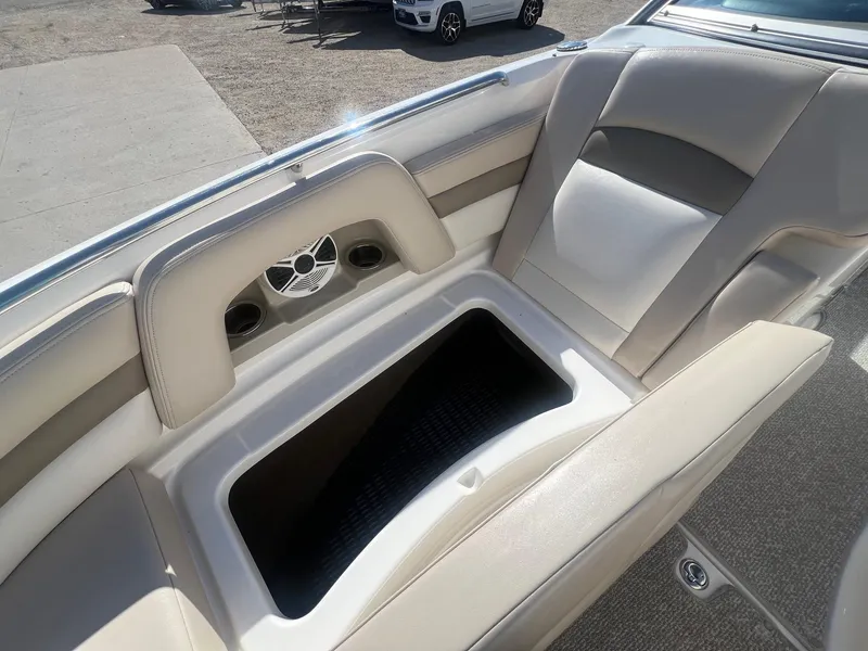Slide: The Image of 2011 Chaparral 264 Sunesta boat interior with beige seating and storage compartment. - 14