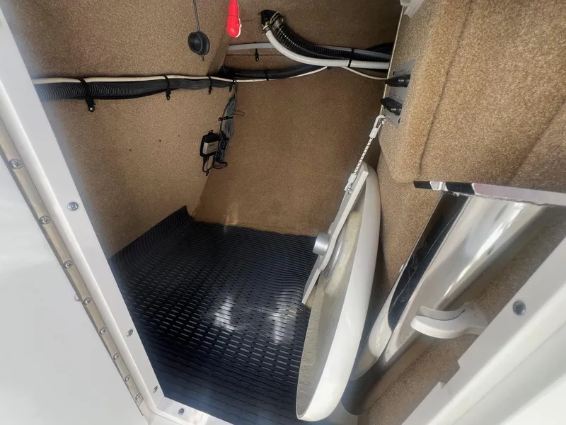 Slide: The Image of Interior storage compartment of 2011 Chaparral 264 Sunesta boat, featuring wiring and equipment. - 17