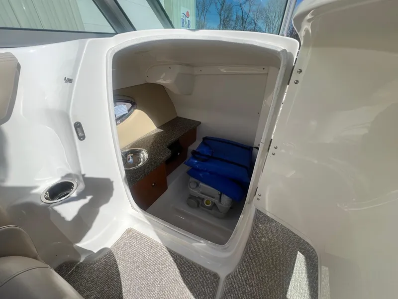 Slide: The Image of 2011 Chaparral 264 Sunesta boat interior with storage compartment and sink. - 19