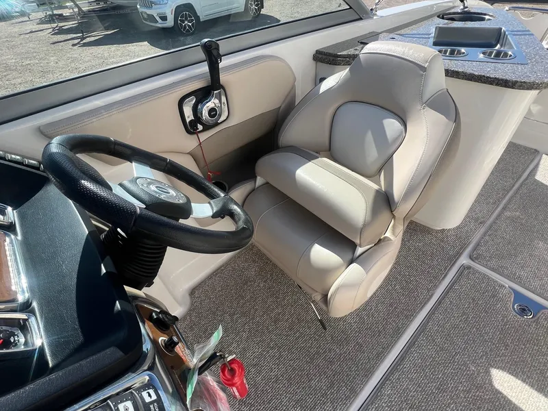 Slide: The Image of 2011 Chaparral 264 Sunesta boat interior with steering wheel and seating. - 23