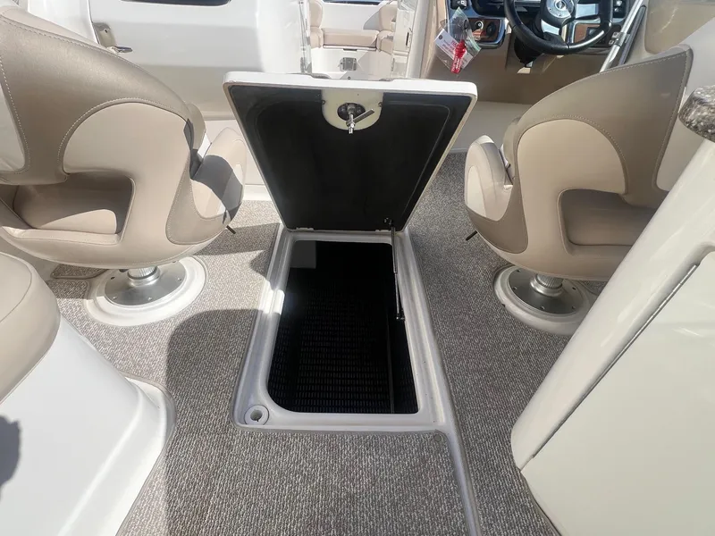 Slide: The Image of 2011 Chaparral 264 Sunesta boat interior with open storage compartment and swivel seats. - 25