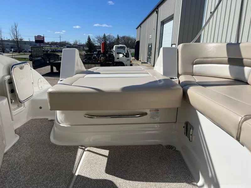 Slide: The Image of 2011 Chaparral 264 Sunesta boat interior with beige seating and storage compartment. - 27