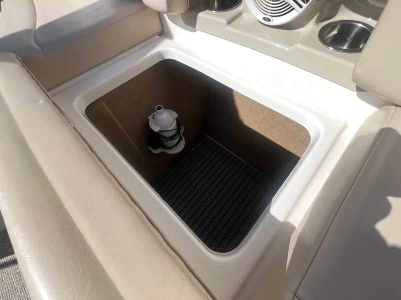 Slide: The Image of Storage compartment in 2011 Chaparral 264 Sunesta boat, featuring cup holders and speaker. - 28