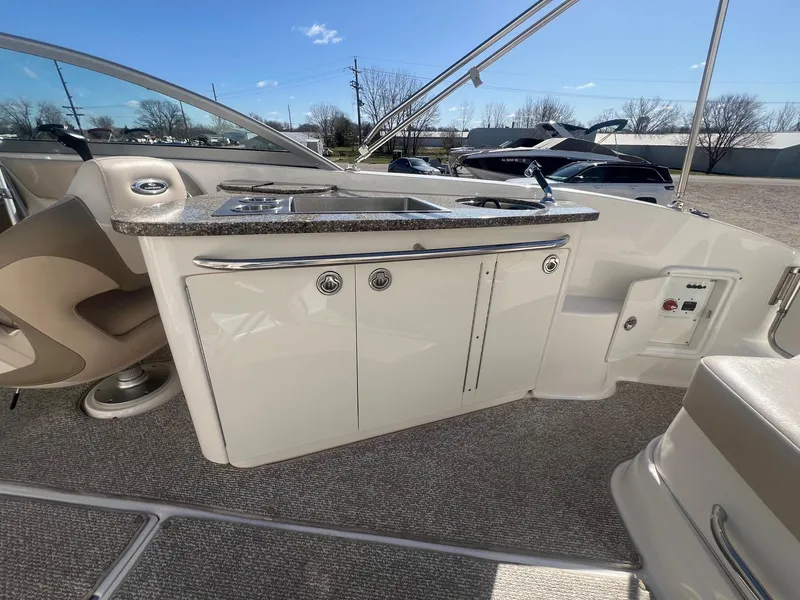 Slide: The Image of 2011 Chaparral 264 Sunesta boat interior with kitchenette and seating area. - 31