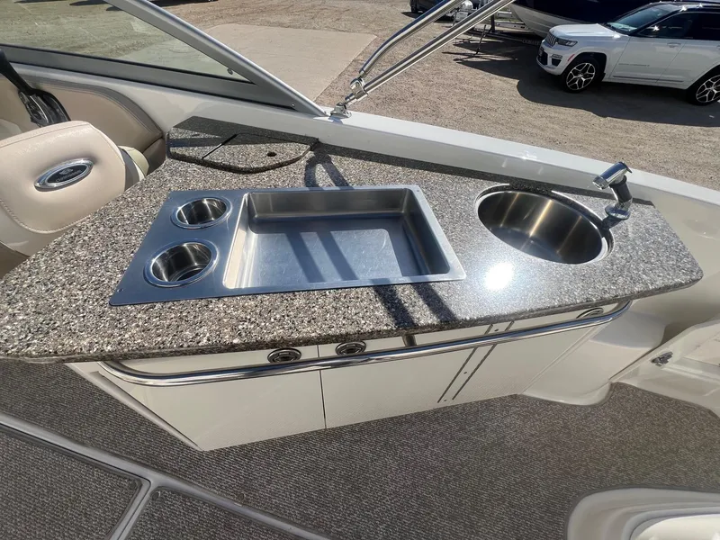 Slide: The Image of 2011 Chaparral 264 Sunesta boat kitchenette with granite countertop, sink, and cup holders. - 33