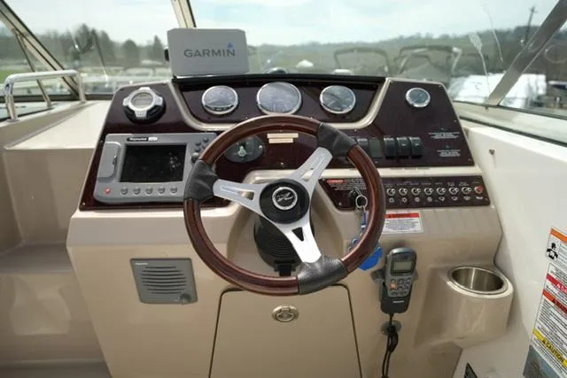 Slide: The Image of 2009 Sea Ray 270 Sundancer helm with Garmin navigation, steering wheel, and control panel. - 11
