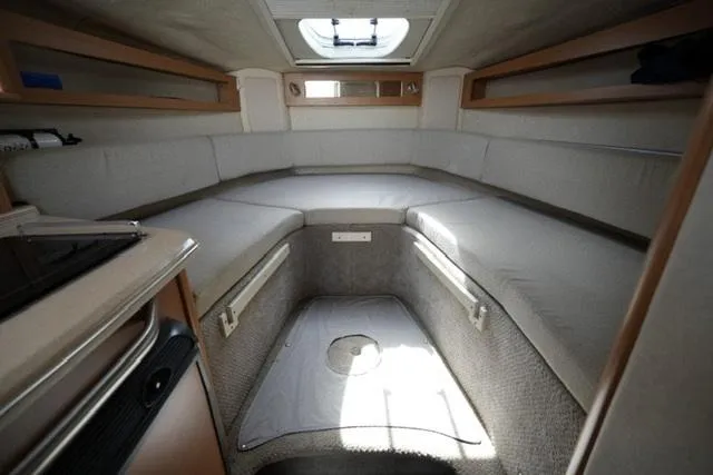 Slide: The Image of 2009 Sea Ray 270 Sundancer cabin interior with seating and overhead hatch. - 14