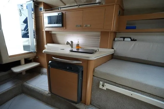 Slide: The Image of Interior of 2009 Sea Ray 270 Sundancer with kitchenette and seating area. - 15