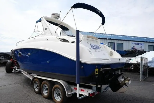 Slide: The Image of 2009 Sea Ray 270 Sundancer boat on trailer, blue and white design, parked outdoors. - 7