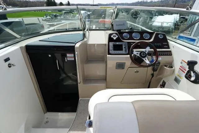 Slide: The Image of 2009 Sea Ray 270 Sundancer boat cockpit with steering wheel and navigation instruments. - 9