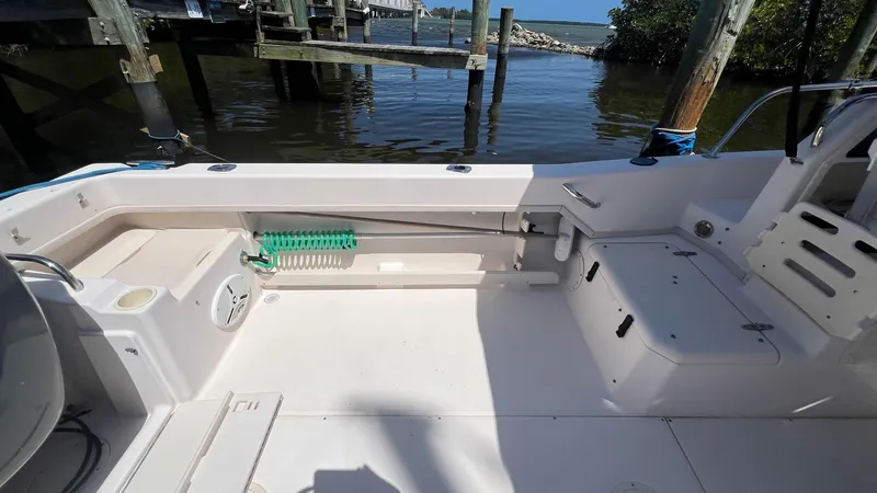 Slide: The Image of 2005 Grady-White Seafarer 226 boat interior, featuring seating and storage, docked by the water. - 16