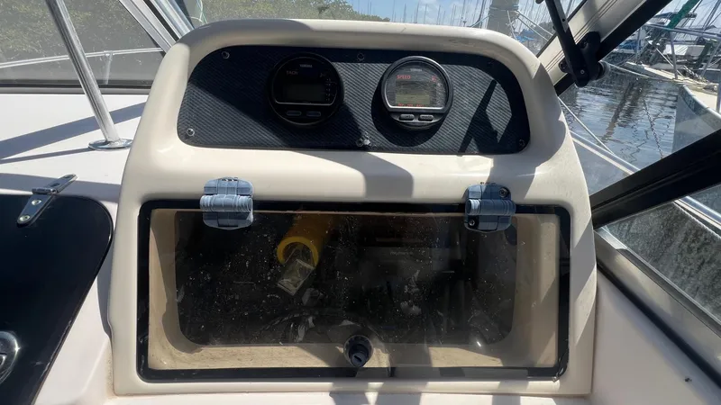 Slide: The Image of 2005 Grady-White Seafarer 226 dashboard with gauges and storage compartment. - 24