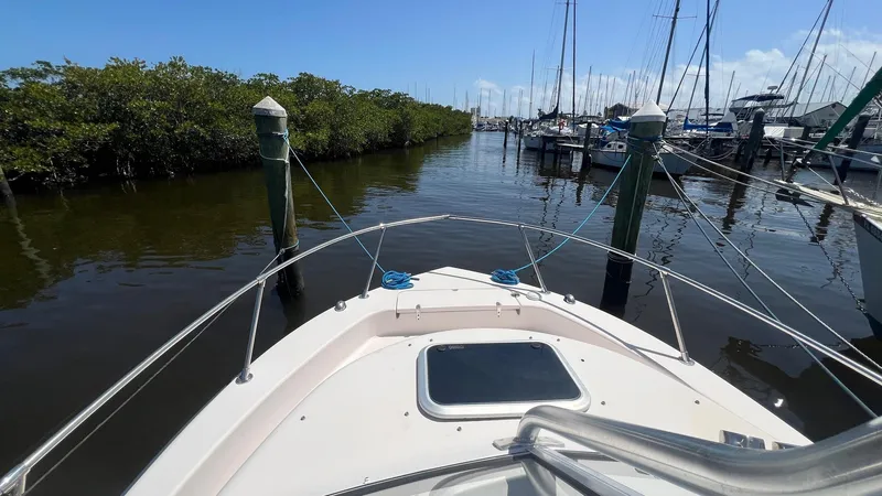Slide: The Image of 2005 Grady-White Seafarer 226 boat docked in a marina, surrounded by calm waters. - 26